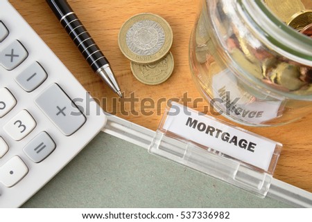 Mortgage file with calculator, pen, coins and glass jar