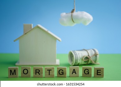 Mortgage And Home Refinance Conceptual With Wooden House On Green And Blue Background