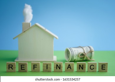 Mortgage And Home Refinance Conceptual With Wooden House On Green And Blue Background