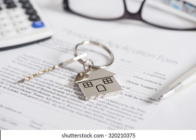 Mortgage loan agreement application with house shaped keyring - Shutterstock ID 320210375