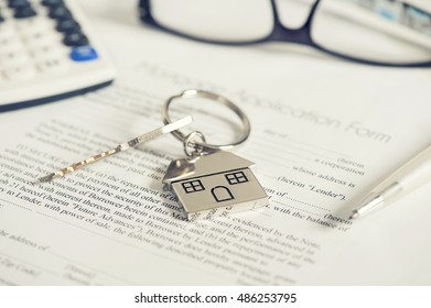 Mortgage loan agreement application with house shaped keyring - Shutterstock ID 486253795