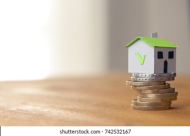 Mortgage And Loan Approved Concept: Paper House On A Coin Pile