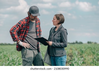Mortgage loan officer assisting farmer in financial allowance application process, banker and farm worker in corn maize crop field.