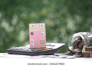 Mortgage, Model house on calculator and stack of coins money on natural green background,Business investment and real estate concept - Shutterstock ID 2366227883