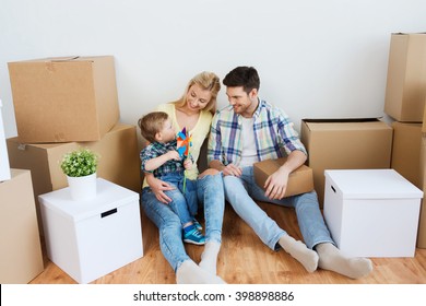 mortgage, people, housing and real estate concept - happy family with boxes moving to new home