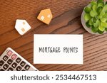 Mortgage points concept. Fees paid to the lender at closing in exchange for a reduced interest rate on a mortgage. Finance and loan. Notebook, calculator and miniature houses