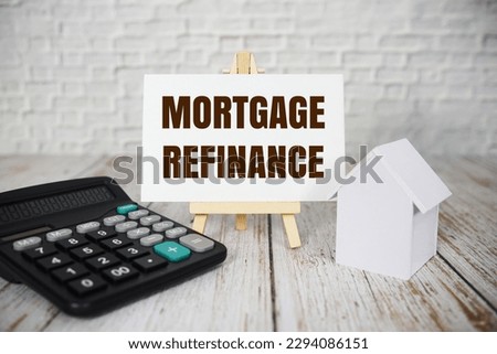 Mortgage refinance text message with calculator and house model on wooden background