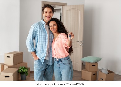 Mortgage and Relocation Concept. Portrait of happy woman hugging man, holding key from new first house, young family celebrating moving day, satisfied customers buyers couple purchase real estate - Shutterstock ID 2075642539