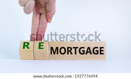 Mortgage or remortgage symbol. Businessman turns cubes and changes the word 'remortgage' to 'mortgage'. Beautiful white background, copy space. Business, Mortgage or remortgage concept.