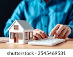 mortgage, residential, financial, rental, finance, investment, purchase, sale, estate, calculator. A man is typing on a keyboard in front of a small white house.