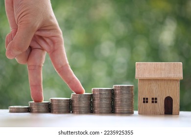 Mortgage,Model house and stack of coins money on natural green background,Business investment and real estate concept - Shutterstock ID 2235925355