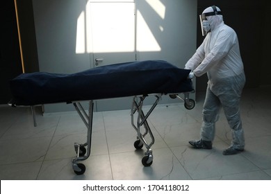 Mortuary Workers Of  The 'Pompes Funebres Fontaine' Funeral Service Company In Protective Suits Transport A Coffin Of A COVID-19 Victim In Gilly, Belgium On Apr. 9, 2020.

