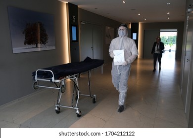 Mortuary Workers Of  The 'Pompes Funebres Fontaine' Funeral Service Company In Protective Suits Transport A Coffin Of A COVID-19 Victim In Gilly, Belgium On Apr. 9, 2020.