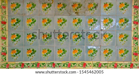 A mosaic of blue tiles decorated with yellow flowers. These are typical of the tiles found on the facade of traditional Chinese Peranakan shop houses.