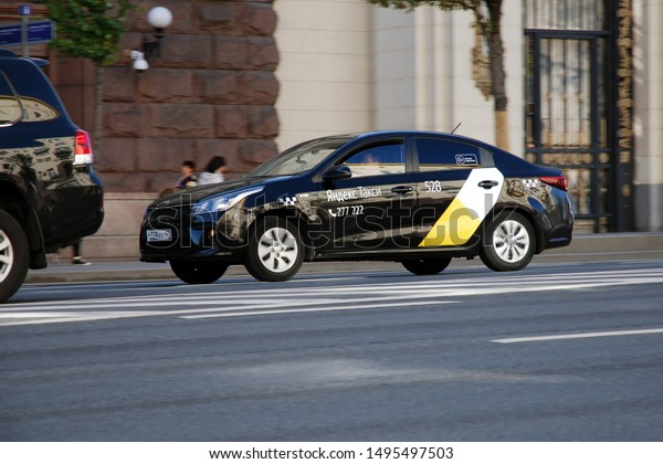 Moscow 01/09/2019 Black yandex taxi cab drives\
along street. Modern taxi\
service.\
