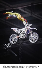 MOSCOW - 14 MARCH,2015: Extreme Sport Competition Show Proryv.Freestyle Motocross Athlete Jump High From Big Air Ramp Performing Dangerous Cliff Hanger Trick On FMX Motor Bike