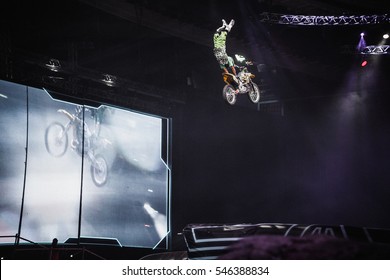 MOSCOW - 14 MARCH,2015: Extreme Sport Competition Show Proryv.Freestyle Motocross Athlete Jump High From Big Air Ramp Performing Dangerous Cliff Hanger Trick On FMX Motor Bike