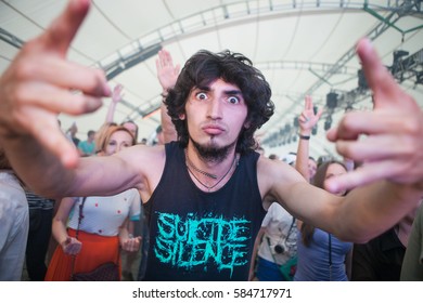 MOSCOW - 19 JUNE,2016:Concert Audience Enjoy Big Live Music Festival Event.Music Fans Have Fun At Crowded Dancefloor.Wild Young Music Fan Guy Show Rock On Gesture.Young Man Enjoying The Show