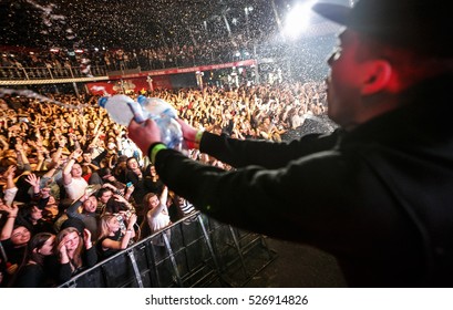 MOSCOW - 30 NOVEMBER,2016: Popular Rap Singer Sing On Scene In Night Club.Big Music Concert In Nightclub.Bright Stage Lighting,crowded Dancefloor.Rapper Throw Water In Crowd.Wild Entertainment Show