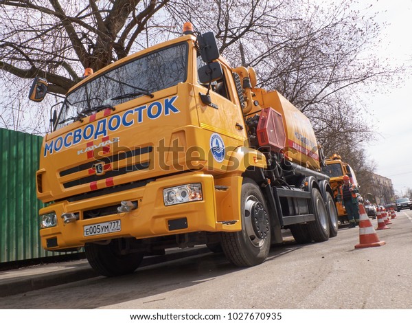 MOSCOW, APR.29, 2017: Diagonal view on yellow\
city service Mosvodostok truck, road signs safety cones. Road water\
drainage cleaning truck and equipment devices tools. Road drainage\
city service