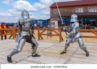MOSCOW - APRIL 2016: Two armored swordsmen dressed as knights fight with swords at knight tournament reconstruction