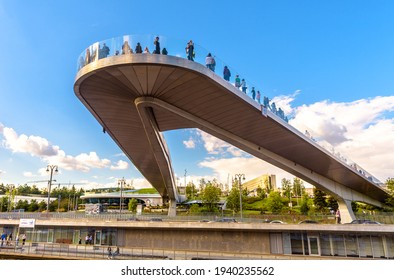 Moscow - Aug 21, 2020: Floating bridge above Moskva River in Zaryadye Park, Moscow, Russia. Zaryadye is famous tourist attractions of city. People stand on amazing hovering bridge in summer.