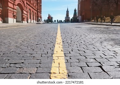 Moscow: Enter to Red Square via Kremlin passage (Kremlevsky proezd).  View of Spasskaya tower of the Moscow Kremlin. Almost empty street. Yellow line of road markings on paving stones. - Shutterstock ID 2217472181