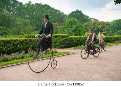 MOSCOW - JUNE 9: Members Of The Historic Bike Ride In The Park Sokolniki On June 9, 2013 In Moscow. At This Event Participants In Period Costumes Ride Vintage And Military Bikes 19-20th Centuries