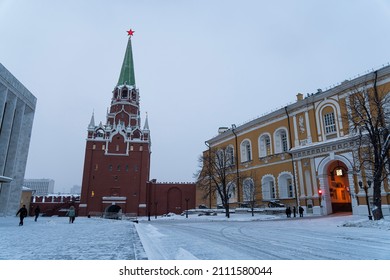 Moscow Kremlin entrance for tourists. People walk on fortress bridge to Troitskaya Tower in winter. December 21, 2021. Moscow, Russia: