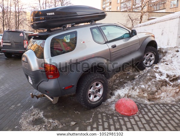 MOSCOW, MARCH, 22, 2018:\
?lose-up of off road car funny parked in a snow pile on winter city\
street. Extreme car parking problem humor concept. Parking place\
ansence