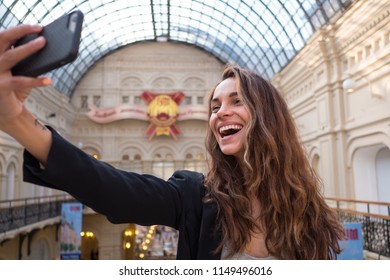 MOSCOW - MAY, 2018: Happy Smiling Young Woman Portrait Taking Selfie Photo Inside Gum Department Store In Moscow.