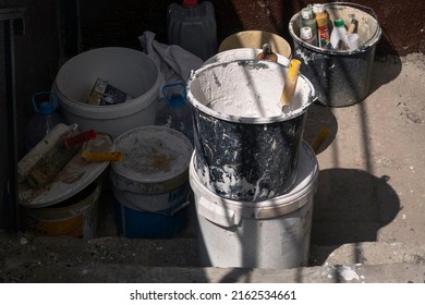 Moscow - May, 2022: Used Dirty Repair Materials And Tools Outdoors, Buckets, Brushes, Containers With Paint. Spring House Or Building Renovation.