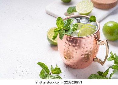 Moscow mule alcoholic cocktail in copper mug with lime, mint and cucumber