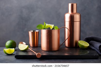 Moscow mule cocktail in copper mug, shaker with fresh mint, lime on marble board. Dark background. Copy space. - Powered by Shutterstock