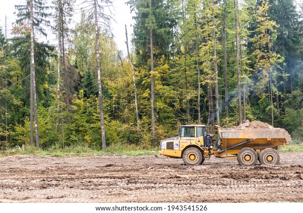 Moscow oblast. Russia.\
Autumn 2019. Off-road truck on road works. A large car carries clay\
in the back