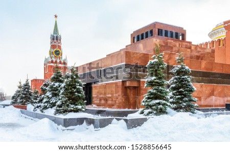 Moscow Red Square in winter, Russia. Lenin's Mausoleum by Moscow Kremlin under snow. This place is a famous tourist attraction of Moscow. The inscription is Lenin. Center of Moscow during snowfall.