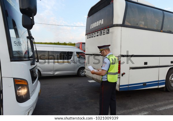 MOSCOW REGION, RUSSIA - AUGUST 3,2017: The\
inspector of the road police patrol stopped the intercity passenger\
bus for inspection.