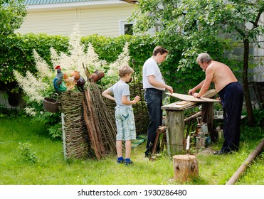 Moscow Region, Russia - June 25, 2011: Grandfather With His Son And Grandson Make A Bird Feeder In A Country House.
The Family Is Doing Carpentry All Together In A Country House In The Village.