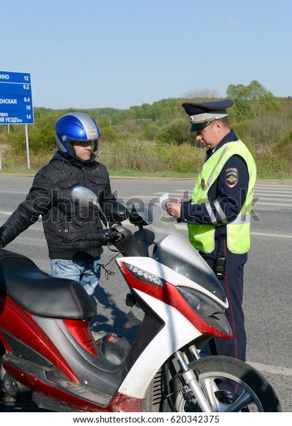 MOSCOW REGION, RUSSIA -\
MAY 14,2016:The inspector of traffic police checks the documents of\
the motorcycle.