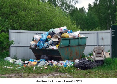 Moscow Region, Russia-May 30, 2020. Overflowing Dumpster At Russian Countryside In Summer Day