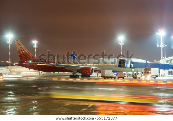 Moscow region, Vnukovo, Russia - December 24,\
2016: Night view of the apron of Vnukovo international airport and\
passenger aircraft Boeing 777-300 EI-UNM Rossiya standing on ground\
handling.