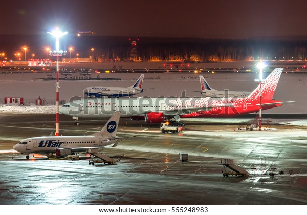 Moscow region, Vnukovo, Russia - December 24,\
2016: Night view of the apron of Vnukovo international airport and\
passenger aircraft Boeing 777-300 EI-UNN Rossiya standing on ground\
handling.