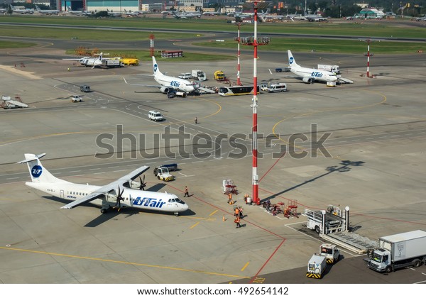 Moscow region, Vnukovo,\
Russia - July 02, 2016: Aerial view on airport airfield and Utair\
aircraft\'s standing at Vnukovo international airport on ground\
handling.