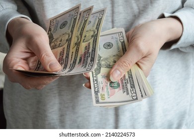 Moscow, Russia, 03.27.2022,a woman counts banknotes with her hands. American money, dollars.