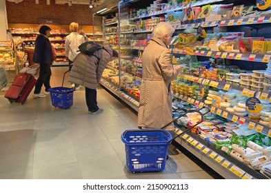 Moscow, Russia - 04.29.2022: An Elderly Woman Stands By The Shelves With Cheese. People With Shopping Baskets In A Grocery Store. Dairy Products. Hyperinflation And Inflation, Food Price Increase