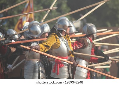Moscow, Russia, 07/08/2012. Big bunch of european pikemen brutally fight with long wooden spears on battlefield during living history festival. Fierce medieval battle. Thirty Years' War. 