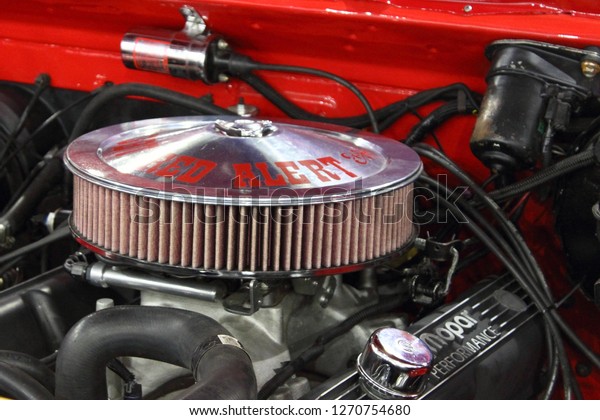 Moscow / Russia – 08 31 2016: Vintage air filter of\
V8  motor engine in old red tuned American muscle car at exhibition\
Moscow International Automobile Salon MMAS 2016 in Crocus Expo,\
motor show