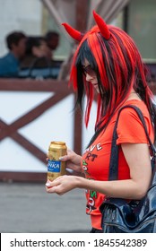 Moscow, Russia, 09.07.2009. Girl with a can of beer and red hair at the Moscow International Beer Festival