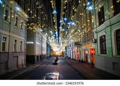MOSCOW, RUSSIA — 10 March 2019: empty Nikolsky lane without people, unusual Christmas decorations against a twilight dark sky                               