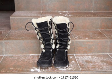 Moscow, Russia - 14th Of February 2021. Black Ugg Boots Are Standing On The Stairs Outside Country House In Winter Day. Editorial Use Only.